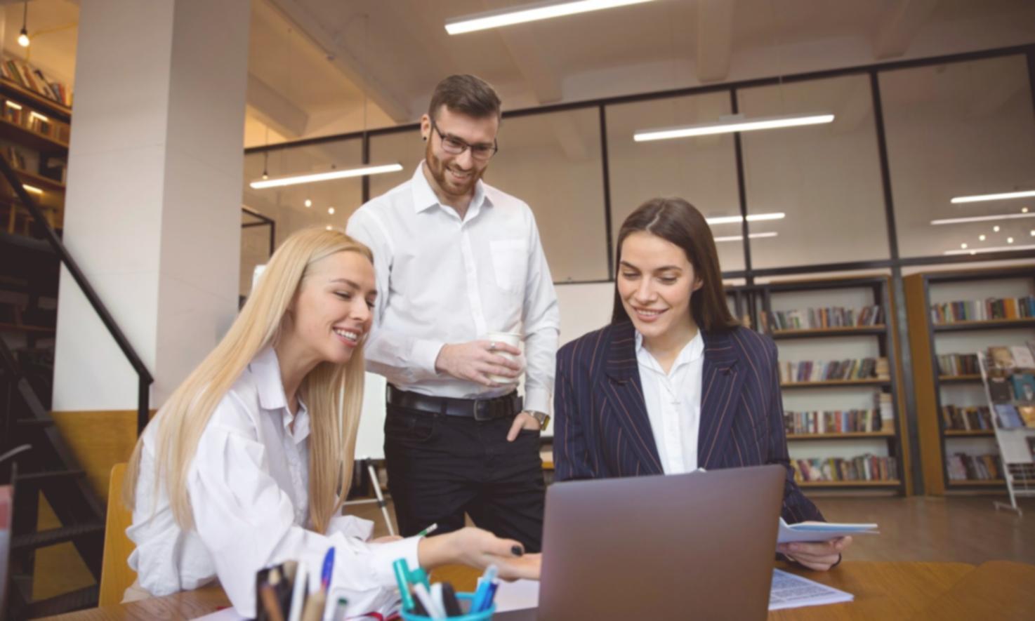 Formatrice expliquant des concepts financiers à une apprenante devant un ordinateur